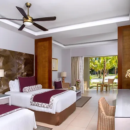 Dreams Royal Beach Punta Cana (Adults Only) Room photo The photo shows a well-lit and spacious hotel room designed for comfort and relaxation. The room features two twin beds with white linens, accented by a deep purple bed runner and decorative pillows with a geometric pattern in purple and white. Each 