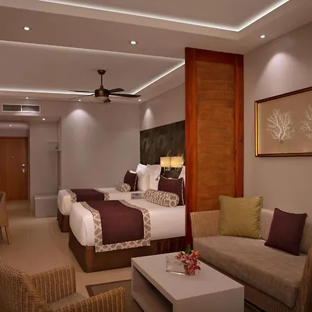Dreams Royal Beach Punta Cana (Adults Only) Room photo The photo shows a well-appointed hotel room with a comfortable and inviting atmosphere. The room features two double beds with crisp white linens, accented by maroon bed runners and patterned pillows. Each bed has a bedside table with a lamp. 

Again