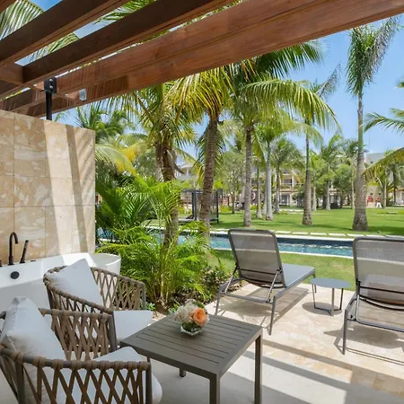Dreams Royal Beach Punta Cana (Adults Only) Amenities photo The photo shows a luxurious outdoor bathroom area, likely part of a high-end villa or resort. The bathroom features a sleek, white freestanding bathtub positioned against a light beige tiled wall. A modern black faucet is installed on the wall next t